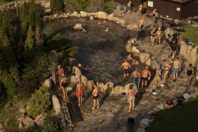 FOTOGRAFÍA. Orense (GALICIA) REINO DE ESPAÑA, 14/04/2024. Nubosidad y descenso de temperaturas en España. Varias personas disfrutan de las altas temperaturas en la zona fluvial del río Miño y las termas de Outariz, durante una jornada en la que se volverán a superar los 30 grados en Orense. La inestabilidad atmosférica vuelve este domingo a la Comunidad debido a la entrada de aire frío en altura que figura en la predicción de Meteogalicia y que provocará que por la tarde aumenten las nubes bajas en el tercio norte y que se formen otras de evolución que pueden derivar en algún chubasco tormentoso, más probable al este. Efe