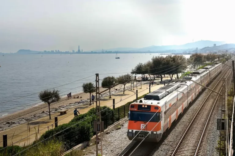 BARCELONA (REINO DE ESPAÑA), 13 DE MAYO DE 2024. Medidas alternativas Rodalies Renfe tras sabotaje. Tren de Rodalies con Barcelona al fondo. Efe