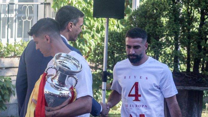 FOTOGRAFÍA. PRESIDENCIA DEL GOBIERNO DEL REINO DE ESPAÑA (MADRID), 15 DE JULIO DE 2024. Sobre el patriotismo del internacional de la selección española de fútbol y defensa en el Real Madrid C. F. de la Primera División del Reino de España, Daniel Carvajal Ramos (Dani Carvajal) (dcha.), quien le dedicó al autócrata comunista Pedro Sánchez Pérez-Castejón (izda.) un saludo muy frío sin ni siquiera mirarle al presidente de un Gobierno de coalición comunista de España que sí buscaba aprovecharse del momento para limpiar su sucia imagen de traidor y destructor del Reino de España, en la recepción de la selección campeona de Europa en la Presidencia de Gobierno del Reino de España por parte del régimen de coalición comunista, La Moncloa. Concretamente, aquél lunes, 15 de julio de 2024, con la celebración de la cuarta Eurocopa por parte de la selección de fútbol masculino del Reino de España por las calles de la ciudad de Madrid, se produjo cuando el equipo llegó a la recepción de Pedro Sánchez Pérez-Castejón en el Palacio de La Moncloa. Los jugadores, encabezados por el capitán de la Selección, Álvaro Borja Morata Martín (Álvaro Morata) (c), bajaron del autobús para dirigirse a la entrada principal de La Moncloa donde Sánchez ya había montado su chiringuito para captar votos fáciles y donde después escucharían su discurso en un ambiente muy triste, frío y con varios insecto como protagonistas -lo que fue para los héroes futbolistas un motivo suficiente para no hacerle caso a un Sánchez traidor cuando este gritaba o vociferaba su cuento comunista y progre- y se harían la foto oficial. Morata, con el trofeo de la Eurocopa en las manos, fue el primero en devolver el saludo a Sánchez. Justo detrás estaba el patriota Carvajal, que saludó a Sánchez con cierta desgana y sin mirarle a la cara, como no podría ser de otra manera; en el Reino de España hay una Resistencia al comunista y globalismo totalitario progre. La respuesta silenciosa e inteligente del disidente español Daniel Carvajal Ramos (Dani Carvajal) no pasó desapercibido por los ojos de casi todo el Reino de España puestos en su Selección heroína en ese momento de celebración. Poco después, la respuesta de Carvajal le convirtió en tendencia en todas las redes sociales, había dado donde a todo el Reino de España le gustaría: manda a su casa al traidor Pedro Sánchez Pérez-Castejón y no estar cada día pactando con él y dándole oxígeno como sí hacen los traidores del socialismo azul Partido popular desde calle Génova 13, presididos por el amigo del narco gallego y separatista Alberto nuñez Feijóo. Efe