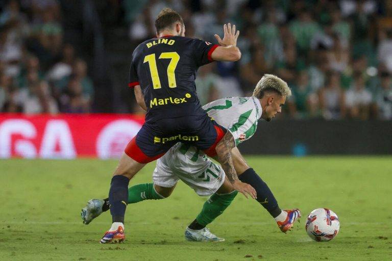 FOTOGRAFÍA. SEVILLA (REINO DE ESPAÑA), 15 DE AGOSTO DE 2024. El centrocampista del Betis Rodri (d) lucha con el neerlandés Daley Blind, del Girona. Efe