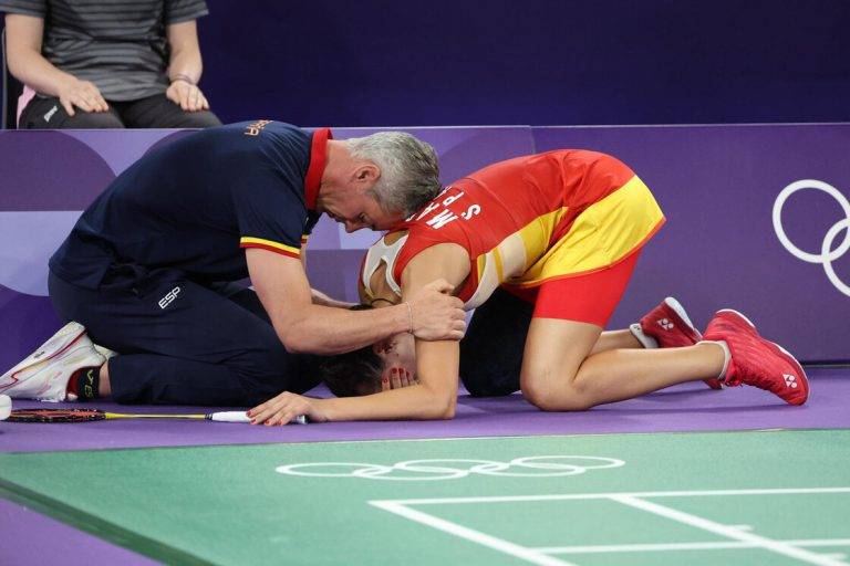 FOTOGRAFÍA. PARÍS (FRANCIA), 04 DE AGOSTO DE 2024. La española Carolina María Marín Martín (Carolina Marín)recibe es consolada por su entrenador Fernando Rivas (i) tras lesionarse en la rodilla derecha durante su partido de semifinales de bádminton ante He Bing Jiao, de China. Efe