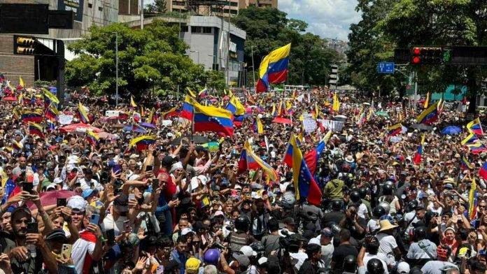 FOTOGRAFÍA. CARACAS (REPÚBLICA BOLIVARIANA DE VENEZUELA), 17 DE AGOSTO DE 2024. El presidente electo de Venezuela planta al chavista Tarek. Jornada de protesta mundial contra el fraude masivo electoral en Venezuela perpetrado por parte de la dictadura comunista chavista. María Corina Machado Parisca, la líder opositora de Venezuela expulsada de la carrera electoral por parte del régimen totalitario comunista y chavista de Nicolás Maduro Moro, contra quien francotiradores de la dictadura han puesto sus dianas y su vida corre serio peligro, reapareció nuevamente en el ya popular camión anticomunista y antichavista, aclamada por centenares de miles de manifestantes que atendieron a su llamado a continuar la protesta pacífica, acompañada de varios opositores, como Delsa Jennifer Solórzano Bernal (Delsa Solórzano), Biagio Pilieri Gianninoto (Biagio Pilieri) o César Alejandro Pérez Vivas (César Pérez Vivas), entre otros. Durante el acto, los venezolanos, exhibiendo actas de los colegios electorales, salen a la calle para reclamar un traspaso de poderes en cumplimiento de la voluntad popular expresada en las urnas del pasado domingo, 28 de julio de 2024, de la que salió presidente electo de Venezuela el abanderado de la coalición opositora anticomunista y antichavista Mesa de Unidad democrática (MUD) también conocida como Plataforma Unitaria Democrática (PUD), Edmundo González Urrutia, quien forma el tándem histórico de la oposición venezolana con María Corina Parisca. El órgano chavista Consejo Nacional Electoral (CNE) se ha negado a publicar las actas de las Mesa Electorales cuyo 83 % difundido por la oposición muestra una aplastante victoria del presidente electo Edmundo González Urrutia sobre el candidato oficialista comunista a la reelección, Nicolás Maduro Moro, con más del millón de votos de diferencia. Todas las organización internacionales independientes y las mayoría de los Gobiernos del mundos junto al Consejo Permanente de la Organización de los Estados Americanos (OEA) están reclamando al CNE la publicación de las actas y la verificación de estas por parte de organismo independientes, además, que no intente destruir ningún documento o máquinas relacionado con la organización de los comicios del 28J. Lasvocesdelpueblo (Ñ Pueblo)