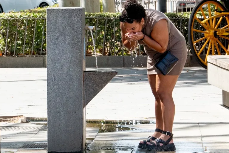 FOTOGRAFÍA. SEVILLA (REINO DE ESPAÑA), 09 DE AGOSTO DE 2024. v.- Una mujer bebe agua para combatir el calor en Sevilla. La Agencia Estatal de Meteorología (Aemet) ha confirmado la llegada de la cuarta ola de calor de este verano en España a partir de este viernes, con temperaturas extremas que pueden tener impacto en la salud de las personas y en los incendios forestales; pero ¿qué es una ola de calor? La Aemet la define como un episodio de, al menos, tres días consecutivos, en el que el 10 % de las estaciones meteorológicas registren valores por encima de la temperatura umbral, correspondiente con el percentil 95 % de su serie de máximas diarias de julio y agosto en el periodo 1971-2000. Efe