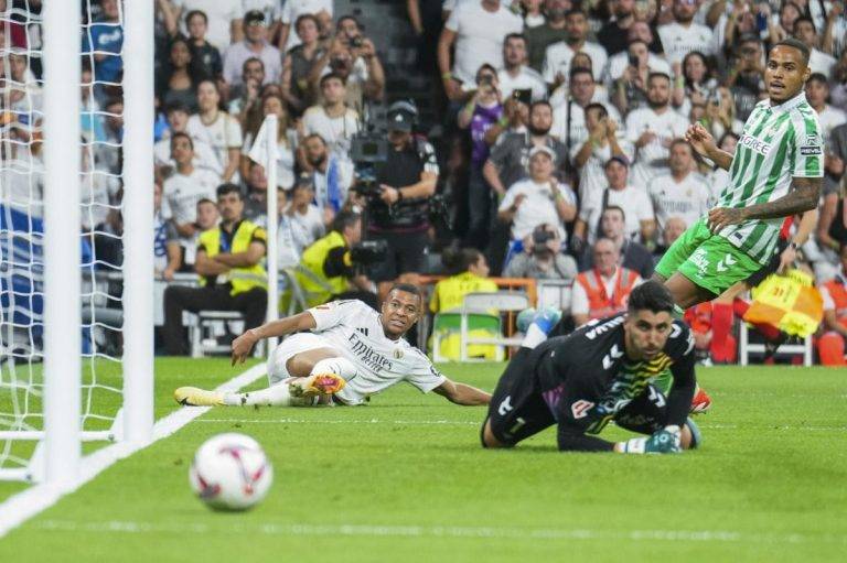 FOTOGRAFÍA. MADRID (REINO DE ESPAÑA), 2 DE SEPTIEMBRE DE 2024. Liberación conjunta ante el Real Betis (2-0).- Kylian Mbappé (d) Partido de la cuarta jornada de LaLiga entre el Real Madrid y el Real Betis, este domingo en el estadio Santiago Bernabéu. Al disparo 25 de Mbappé llegó el gol tan soñado durante su vida, el primero en el Santiago Bernabéu, tan anhelado por el madridismo. Lo celebró sintiendo liberación. Fruto de una genialidad de Fede Valverde, con una asistencia de tacón que habilitó a un 9 que aumenta su efectividad cuando arranca desde la izquierda. La primera cita en la que fue decisivo con un doblete, el segundo de penalti, en un momento del segundo acto en el que el partido podía caer para cualquiera de los dos lados. Efe