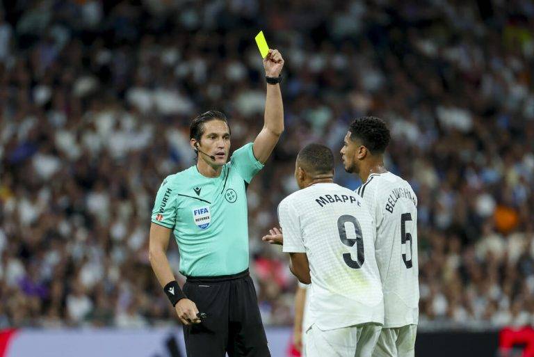 FOTOGRAFÍA. MADRID (REINO DE ESPAÑA), 21 DE SEPTIEMBRE DE 2024. Un poco de Vinícius ante el Espanyol vale oro (4-1).- El árbitro José Luis Munuera Montero muestra la tarjeta amarilla al delantero francés del Real Madrid Kylian Mbappé (2d) durante el encuentro correspondiente a la sexta jornada de Laliga EA Sports en el estadio Santiago Bernábeu, en Madrid. Efe