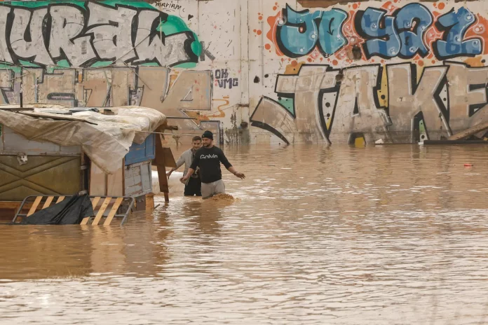 DANA VALENCIA, INUNDACIONES (7) FOTOGRAFÍA. VALENCIA (VALENCIA) COMUNIDAD VALENCIANA (REINO DE ESPAÑA, 30 DE OCTUBRE DE 2024. Dos personas vadean un terreno de chabolas inundado junto a la V-30 a causa de las lluvias torrenciales de las últimas horas. Las redes, de nuevo más sociales que nunca; son otra vez el espejo de la desesperación y el sufrimiento, también de la solidaridad, que están desencadenando las lluvias torrenciales durante las últimas horas en varias comunidades autónomas. "07:28 horas. Hay un hombre muerto en mi casa. Necesito ayuda. Orba 10-19 de Benetússer. Estoy con dos niños y dos personas mayores. Una de ellas sin movilidad". Es el grito desesperado de una mujer que refleja la angustia que se vive en muchos lugares; el vídeo que acompaña su clamor muestra unas calles completamente arrasadas por el paso del agua. Pero el hilo que se sucede a continuación rebosa palabras de ánimo y de solidaridad. "No estáis solos"; "la ayuda va en camino"; "ánimo, mantened la calma"; responden los ciudadanos, que hasta se ofrecen y piden el teléfono para poder hablar y trasladar verbalmente esos mensajes de apoyo mientras llega la ayuda a decenas de lugares. Una Depresión Aislada en Niveles Altos (DANA) tras fuertes lluvias torrenciales y golpear muy fuertemente al reino de España, con epicentro en la provincia de Valencia (Comunidad Valenciana) donde se ha registrado al 92 muertos y con menos dureza en la provincia de Málaga (Andalucía) y en la región de Castilla-La Mancha. La devastación de los efectos de la dana que arrasó este martes la provincia de Valencia deja decenas de personas fallecidas -70 contabilizadas hasta las 16.00 horas-, la angustia de quienes no pueden contactar con sus familiares desde ayer e imágenes desoladoras de la destrucción que han dejado a su paso las inundaciones. En medio de la tragedia, que ha llevado a activar el protocolo de Múltiples Víctimas para identificar a los fallecidos, las autoridades combaten este miércoles un "nuevo enemigo": los bulos que alertan de supuestas evacuaciones, desbordamientos o la caída del 112, que interrumpen la labor de los servicios de emergencias. La ciudadanía de la provincia ha recibido a primera hora de esta mañana de nuevo en sus móviles un mensaje del sistema Es-Alert para evitar cualquier tipo de desplazamiento por las carreteras de la provincia, muchas de cuales permanecen cortadas e impiden todavía acceder a las zonas más afectadas. Efe