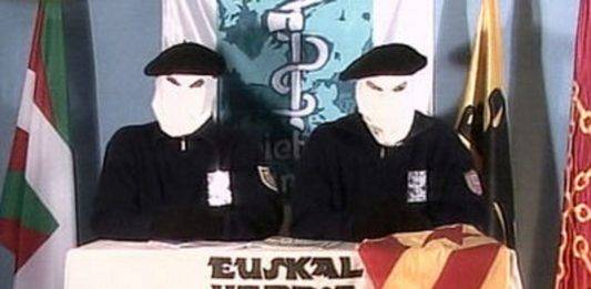 FOTOGRAFÍA. SAN SEBASTIÁN (LAS VASCONGADAS) REINO DE ESPAÑA. 18 DE FEBRERO DE 2004. Con el trapo de la separación de Cataluña del resto del Reino de España "Estrellada" sobre su mesa por primera vez, dos terroristas encapuchados del grupo terrorista comunista separatista "Euskadi Ta Askatasuna (ETA)', expresión en lengua regional de País Vasco, euskera, traducible al español como "País Vasco y Libertad", un organización asesina de tiro a la nuca y coches bomba, aparece durante su habitual lectura de comunicado, donde anuncian que "van a dejar de matar en Cataluña", tras su masacre en Hipercor. El 18 de febrero de 2004 ETA hace público un comunicado en el que anuncia una tregua solo en Cataluña, no en el resto de España. Afirma en el comunicado que lo hace porque Cataluña al igual que el País Vasco es una "nación oprimida" por España y Francia. Los dos asesinos separatistas comunistas etarras encapuchados que aparecen en el vídeo explican también que se ha producido un cambio político. El anuncio se conoce mes y medio después de la reunión del dirigente de la ultraizquierda separatista Esquerra Republicana de Catalunya (ERC), Josep Lluís Carod Rovira, con el sanguinario etarra en Francia, José Antonio Urrutikoetxea Bengoetxea (Miravalles, Vizcaya, 24 de diciembre de 1950), también conocido como "Josu Ternera",​ un terrorista español que perteneció a Euskadi Ta Askatasuna (ETA), y posteriormente fue diputado en el Parlamento Vasco por "Euskal Herritarrok" entre 1998 y 2005. Lasvocesdelpueblo (Ñ Pueblo).
