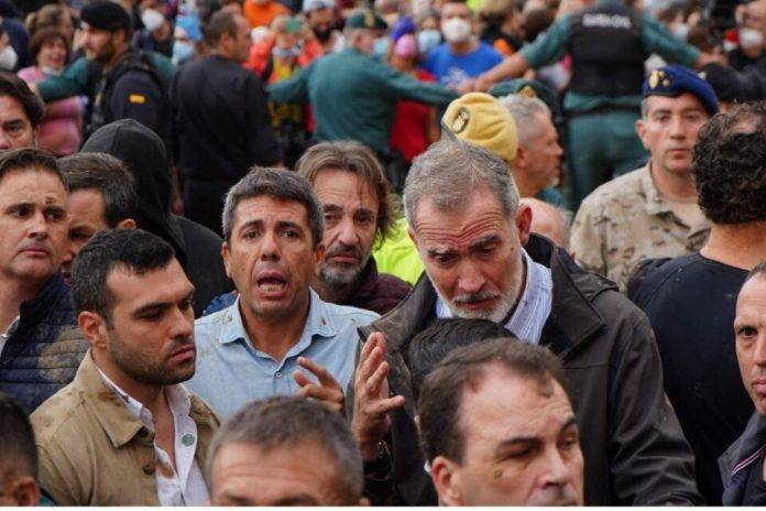 FOTOGRAFÍA. PAIPORTA (VALENCIA) COMUNIDAD VALENCIANA (REINO DE ESPAÑA, 03 DE NOVIEMBRE DE 2024. Gritos de 'fuera', así como lanzamiento de barro, han recibido a la comitiva de sus majestades los reyes de España, el presidente del Gobierno de España, Pedro Sánchez Pérez-Castejón (PSOE), y el president del Govern de la Generalitat Valenciana, Carlos Mazón Guixot (PP), a su llegada al centro de Paiporta (Valencia) -zona cero del apocalipsi sobre la provincia de Valencia, la Depresión Aislada en Niveles Altos (DANA) o (gota fría) del martes 29 y miércoles 30 de octubre de 2024. Decenas de voluntarios y vecinos de Paiporta indignados tras sufrir el claro abandono de todas las instituciones del estados durante varios días en los han estado conviviendo con cadáveres de sus seres queridos en los refugios y otros sitios improvisados, han recibido con insultos a la comitiva, con gritos de "fuera, fuera" dirigido a los dos principales responsables: Pedro Sánchez Pérez-Castejón (PSOE) y Carlos Monzón Guixot (PP), y se han encarado con ella, mientras que tanto el rey como la reina ha intentado mediar con jóvenes que se les han acercado. Con la cara manchada de barro, igual que su abrigo, el rey ha seguido avanzando por una de las calles principales de esta localidad de la zona cero de la dana y ha tratado de tranquilizar a varios de los voluntarios, muy alterados tras cinco días de desastre por la riada. La reina también ha dialogado con algunos de los indignados, mientras que seguían los gritos de 'fuera, fuera' y algunos insultos dirigidos a todas las autoridades. Aunque en un principio la seguridad ha comenzado a abrir paraguas para evitar la caída de barro a la comitiva, posteriormente los han cerrado mientras que el rey seguía caminando y deteniéndose a hablar con los voluntarios y vecinos alterados. Efe.