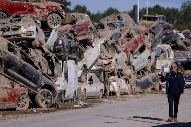 FOTOGRAFÍA. CATARROJA (VALENCIA) COMUNIDAD VALENCIANA (REINO DE ESPAÑA, 20 DE NOVIEMBRE DE 2024. Un hombre pasa ante los innumerables coches apilados este miércoles en Catarroja, tres semanas después de la tragedia provocada por la Depresión Aislada en Niveles Altos (DANA) o (gota fría). Efe