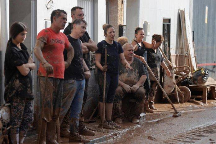 FOTOGRAFÍA. RIBA-ROJA (VALENCIA) COMUNIDAD VALENCIANA (REINO DE ESPAÑA), 01 DE NOVIEMBRE DE 2024.- Vecinos de la Masía del Oliveral, en Riba-Roja, permanecen cubiertos del barro, este viernes. La búsqueda de desaparecidos, la identificación de víctimas mortales, las tareas de limpieza y la reparación de infraestructuras continúan tres días después de las inundaciones que han asolado la provincia de Valencia, en una jornada en la que el Gobierno envía a 500 militares más, que se sumarán a las 1.200 efectivos de la Unidad Militar de Emergencias (UME), para actuar en Utiel, Requena, Riba-roja, Torrent, Paiporta y Algemesí. Efe