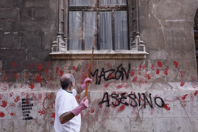 FOTOGRAFÍA. VALENCIA (COMUNIDAD VALENCIANA) REINO DE ESPAÑA, 09 DE NOVIEMBRE DE 2024.- Un hombre limpia las pintadas "Mazón dimisión", en alusión al president del Govern en minoría de la Generalitat Valenciana del dirigente del Partido Popular (PP), Carlos Mazón Guixot), en la  fachada del Palacio del Govern de la Generalitat Valenciana este domingo tras la manifestación de ayer, sábado 9 de noviembre, en la que cerca de 40 organizaciones sociales, cívicas y sindicatos de izquierda de la Comunitat Valenciana han marchado en protesta por la gestión de la Depresión Aislada en Niveles Altos (DANA) o (gota fría) y con el lema "Mazón dimisión", y en la que se ha registra momentos de tensión entre la extrema izquierda y los agentes de las Fuerzas de Seguridad del Estado (Cuerpo Nacional de Policía). Efe