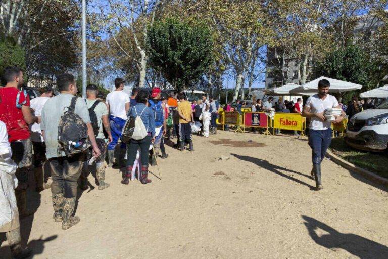 FOTOGRAFÍA. CATARROJA (VALENCIA) COMUNIDAD VALENCIANA (REINO DE ESPAÑA, 10 DE NOVIEMBRE DE 2024. "En Valencia, la paella de los domingos es algo sagrado", cuenta Xavi, vecino de Catarroja, muy agradecido por poder continuar con esta tradición gracias a una empresa de paellas gigantes que ha repartido raciones gratis para dar algo de alegría y de normalidad en la zona cero de la Depresión Aislada en Niveles Altos (DANA) o (gota fría). Como Xavi, cientos de vecinos de Catarroja, a unos diez kilómetros de València, han disfrutado este domingo de su ración de paella gratis tras esperar pacientemente la cola que llegaba hasta el puesto, situado en medio de un parque del pueblo. Efe