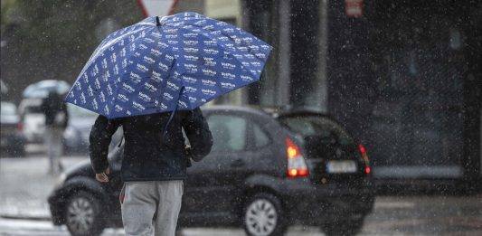 FOTOGRAFÍA. MÁLAGA (ANDALUCÍA) REINO DE ESPAÑA, 12 DE DICIEMBRE DE 2024. Una persona se protege de la lluvia en Málaga este jueves., 12 de diciembre de 2024. Efe
