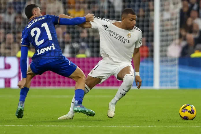 FOTOGRAFÍA. MADRID (COMUNIDAD DE MADRID) REINO DE ESPAÑA, 01 DE DICIEMBRE DE 2024. Después de su desacertada noche en Anfield, Kylian Mbappé (d) volvió a su casa, el Santiago Bernabéu, y la afición del Real Madrid arropó a su futbolista en un partido contra el Getafe en el que marcó un gol, pero en el que mostró dudas a la hora de tirar dos penaltis -uno finalmente anulado tras la revisión en el VAR-. Efe