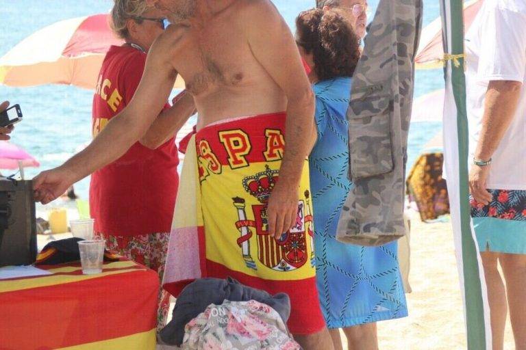 FOTOGRAFÍA. «PLAYA DEL PINO» (PLATGE DEL PÍ) DE PINEDA DE MAR (BARCELONA) ESPAÑA, 11.08.2019. Vista de las sombrillas españolas y un grupo de personas la mañana de éste domingo en la «Playa del Pino» de pineda de Mar (Barcelona), durante la sexta edición de la segunda temporada de plantada de sombrillas españolas en Cataluña. Ñ Pueblo Lasvocesdelpueblo