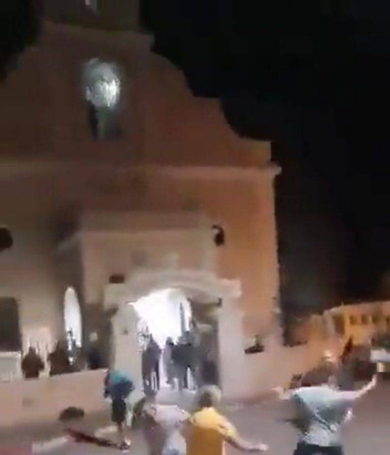 FOTOGRAFÍA. BELÉN (CISJORDANIA, NOCHEBUENA 24 DE DICIEMBRE DE 2024. La ciudad de Belén registra un asedio de su Parroquia con familias cristianos dentro de ella celebrando la Misa del Nacimiento del bebé Jesús, por parte de grupos islamofascistas palestinos, quienes atacan la Misa y a sus asistentes con piedras enormes y resto de objetos contundentes mientras le fieles cristianos solo pueden esconderse, huir de la Iglesias tapando sus cabezas,o intentar defenderse para salvar su Nochebuena frente a los invasores, intolerantes y totalitarios de ultraizquierda palestinos que se llevan todo por delante en nombre de su religión islámica. Un grupo muy reducido e impotente de agentes de policía de la llamada "Autoridad Palestina" del tirano ultra y antisemita Mahmud Ridha Abás llega en la zona, pero parece más colaborador necesario con los agresores que agentes del orden. Captura vídeo ACOM/Lasvocesdelpueblo (Ñ Pueblo)