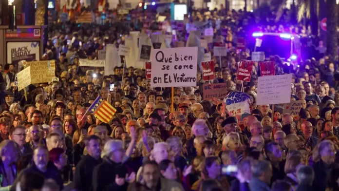 FOTOGRAFÍA. VALENCIA (COMUNIDAD VALENCIANA) REINO DE ESPAÑA, 30 DE NOVIEMBRE DE 2024. Hablan los carteles improvisados de manifestantes: "Govern de la Criminalitat Valenciana 20:11 horas (del 29 de octubre de 2024)"; "els nostres pobles plens de fang - les vostres mans plenes de sang (nuestros pueblos llenos de fango-vuestras manos llenas de sangre (de víctimas de la DANA)"; "No oblida (no olvida)"; "20:11 hores (del 29 d'octubre de 2024) L'hora de la vergonya (20:11 horas del 29 de octubre de 2024 - Hora de la vergüenza); Mazón dimisión (Carlos Mazón Guixot -PP-, presidente del Govern valencià)". Un mes después de la dana y veintiún días desde la multitudinaria manifestación que exigió la dimisión del president de la Generalitat, Carlos Mazón, por su gestión de la catástrofe, los mismos organizadores de esa convocatoria han llamado nuevamente a una masiva protesta en la calle este sábado en Valencia. Efe