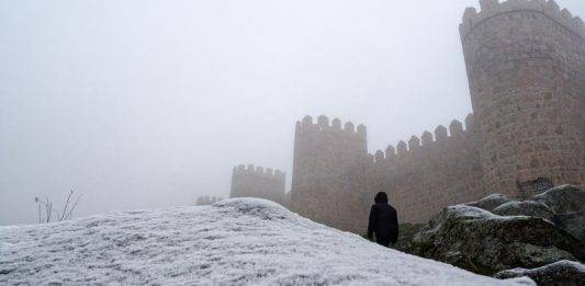 FOTOGRAFÍA. ÁVILA (CASTILLA Y LEÓN) REINO DE ESPAÑA, 31 DE DICIEMBRE DE 2024. Una persona camina junto a la muralla de Ávila (Comunidad Autónoma de Castilla y León), entre la niebla, este martes 31 de diciembre de 2024. Efe