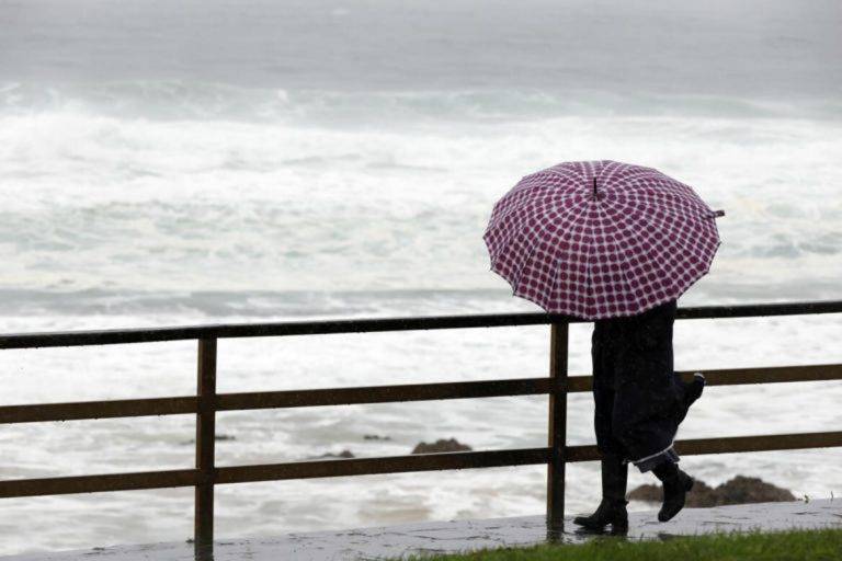 FOTOGRAFÍA. VALDOVIÑO (GALICIA) REINO DE ESPAÑA, 26 DE ENERO DE 2025. Una mujer camina junto a la costa de Valdoviño (Comunidad Autónoma de Galicia) Reino de España, donde la lluvia persistente impide una buena visibilidad y todavía no muestra oleajes de grandes alturas. Galicia espera la llegada de los efectos de la borrasca Herminia que anuncia fuerte oleaje en la costa gallega. Efe