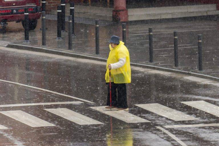 FOTOGRAFÍA. TERUEL (REINO DE ESPAÑA), 03 DE MARZO DE 2025. Una mujer cruza un paso de cebra bajo la lluvia este lunes en Teruel. Efe
