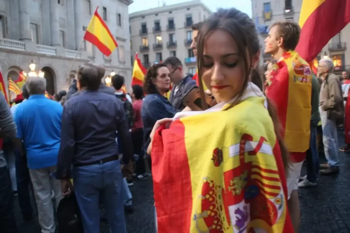 FOTOGRAFÍA. PLAZA SAN JAIME (BARCELONA) CATALUÑA (REINO DE ESPAÑA, 30 DE SEPTIEMBRE DE 2017. Más de 10.000 catalanes salen de su silencio y se levantan contra el golpe de estado separatista que el Gobierno de Carles Puigdemont Casamajó (Convergencia i Unión, CiU); y Oriol Junqueras Vies (Esquerra Republicana de Catalunya, ERC) -presidente y vicepresidente, respectivamente, y jefes de la banda de los okupas de la Generalitat de Catalunya- va a perpetrar mañana, domingo 1 de octubre de 2017 en toda la Comunidad autónoma de Cataluña. El Gobierno central de Mariano Rajoy Brey (Partido popular, PP) parece no saber qué hacer dado que hasta ahora ha dejado que las urnas lleguen prácticamente en todos los colegios electorales ilegales y, tampoco, todo apunta que no hará nada para impedir la apertura de los centro de votaciones ilegales hasta que inicie el golpe de estado, dado que en esto momentos, los separatistas ya se han movilizado para pasar la noche en algunos de los centros clandestinos de votaciones. En la imagen, la joven catalana Laura, una de los jóvenes catalanes que han decidido finalmente dar la cara por su patria en Cataluña, "tarde", pero, subrayan, a partir de ahora, estaremos en las calles porque "nadie me va a echar de mi casa" en Cataluña, explica en declaraciones al diario digital Lasvocesdelpueblo al frente del Palacio del Gobierno de la Generalitat de Catalunya en cuyo techo ondea aún la bandera nacional del Reino de España, la rojigualda, junto a la bandera oficial de la región catalana, la "señera". Lasvocesdelpueblo (Ñ Pueblo).