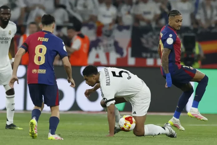 FOTOGRAFÍA. SEVILLA (ANADALUCÍA) REINO DE ESPAÑA, 26 DE ABRIL DE 2025. La centrocampista británico del Real Madrid Jude Bellingham (d) cae al suelo junto a Pedri, del FC Barcelona, durante la final de la Copa del Rey que disputaron Real Madrid y FC Barcelona hoy sábado en el estadio de La Cartuja, en Sevilla. Efe