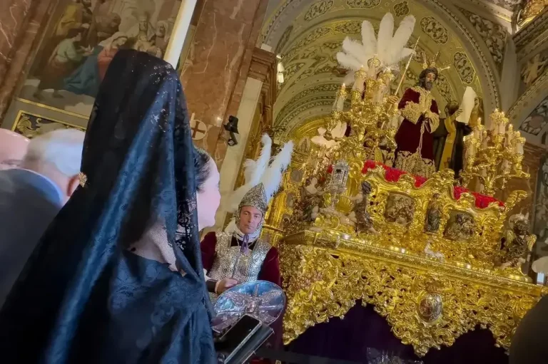 FOTOGRAFÍA. SEVILLA (ANDALUCÍA) REINO DE ESPAÑA, 17 DE ABRIL DE 2025. Una mujer frente al paso de la Macarena y el Sentencia, de la hermandad de la Macarena, este jueves santo, en Sevilla. Efe