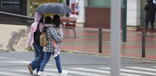 FOTOGRAFÍA. TOLEDO (REINO DE ESPAÑA), 11 DE ABRIL DE 2025. El tiempo inestable protagonizará la Semana Santa. n la imagen una familia camina bajo la lluvia en Toledo. Efe