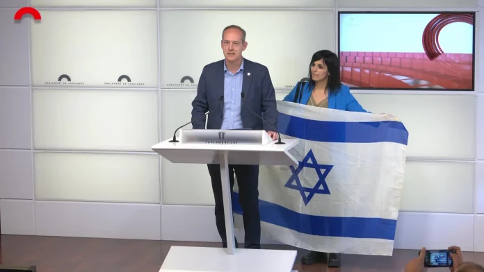 Apoyo firme de Alianza Catalana a Israel ante boicots y vetos en Cataluña por la guerra en Gaza contra Hamas ISIS ¡Viva Israel y viva Cataluña! FOTOGRAFÍA. BARCELONA (REINO DE ESPAÑA), 21 DE MAYO DE 2025. Los dirigentes del nuevo partido patriota separatista Alianza Catalana (AC), la líder de la formación y diputada por Gerona al Parlamento de Cataluña y alcaldesa de Ripoll (Gerona), Sílvia Orriols Serra; y el diputado por Lérida al Parlamento de Cataluña, Ramón Abad Gimeno, registrados este miércoles en el Palacio del Parlamento catalán durante una rueda de prensa. La formación exhibe una bandera nacional de Israel en apoyo al pueblo judío y a Israel frente a las campañas de boicots y vetos masivos de los grupos antisemitas WOKE y a los que se han sumado las Instituciones por defenderse Israel contra la ofensiva racista y nazi de los grupos terroristas en Gaza: Hamas ISIS e Yihad Islámica Palestina (YIP) ISIS. Lasvocesdelpueblo (Ñ Pueblo)