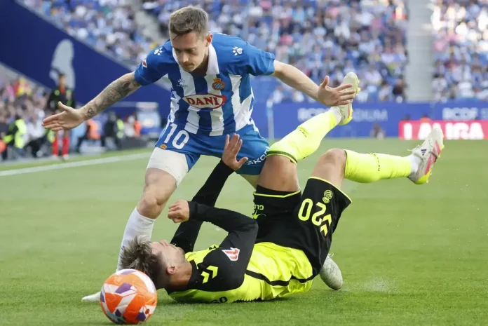 FOTOGRAFÍA. CORNELLÁ DE LLOBREGAT (BARCELONA) CATALUÑA (REINO DE ESPAÑA), 04 DE MAYO DE 2025. El centrocampista del Espanyol Pol Lozano (i) pelea un balón ante el centrocampista argentino del Betis Giovani Lo Celso este domingo, durante el partido de la jornada 34 de LaLiga EA Sports, entre el RCD Espanyol y el Real Betis Balompié, en el RCDE Stadium de Cornellà de Llobregat (Barcelona). Efe