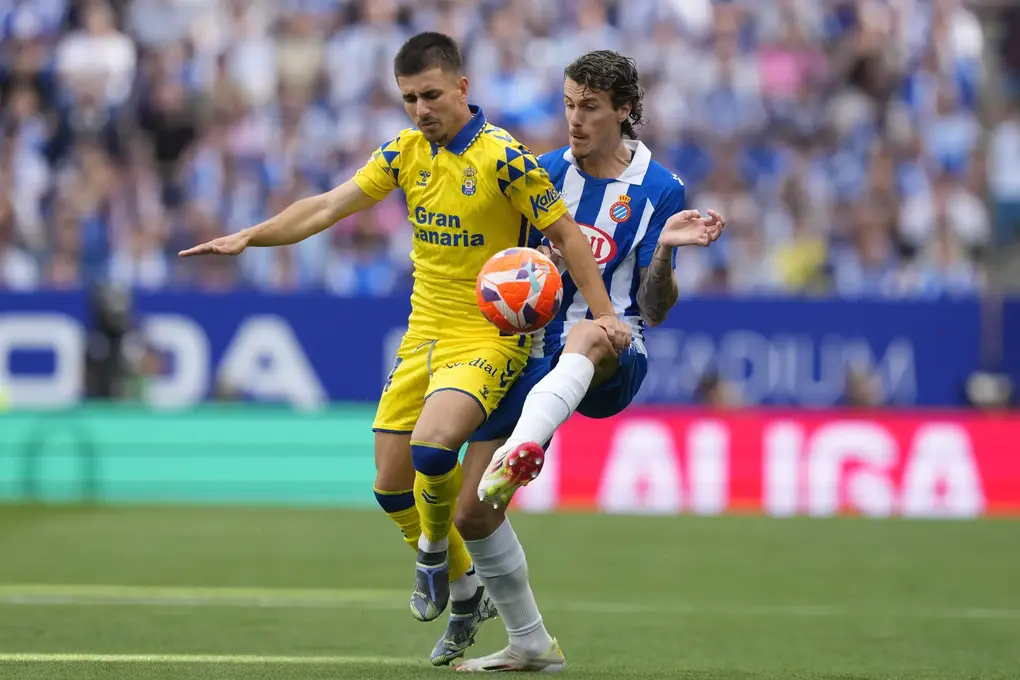 FOTOGRAFÍA. CORNELLÁ DE LLOBREGAT (BARCELOAN) REINO DE ESPAÑA, 24 DE MAYO DE 2025. El defensa del Espanyol Carlos Romero (d) pelea un balón con Manuel Fuster, de Las Palmas, durante el partido de LaLiga de fútbol que RCD Espanyol y UD Las Palmas disputan este sábado en el RCDE Stadium. en Barcelona. Efe