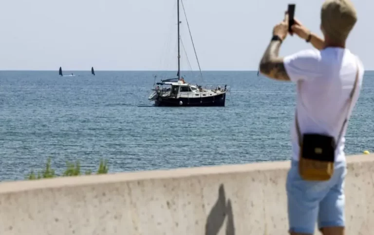 FOTOGRAFÍA. VALENCIA (COMUNIDAD VALENCIANA) REINO DE ESPAÑA, 23 DE JUNIO DE 2025. Un hombre saca una foto junto a un velero en la playa de la Malvarrosa en Valencia este lunes. Efe