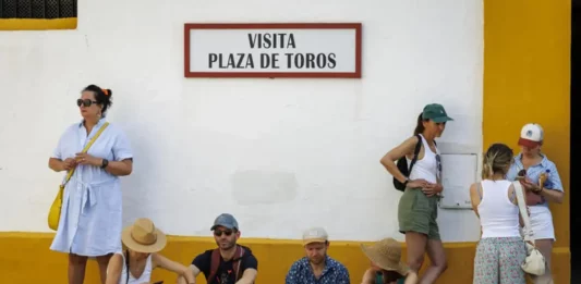 FOTOGRAFÍA. SEVILLA (COMUNIDAD AUTÓNOMA DE ADALUCÍA) REINO DE ESPAÑA, 07 DE JUNIO DE 2025. Unos turistas descansaban este sábado a la sombra en la entrada de la Plaza de Toros de la Maestranza de Sevilla. Efe