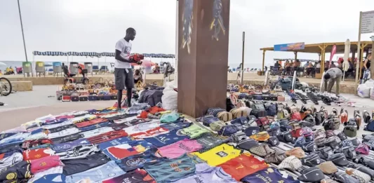 FOTOGRAFÍA. PASEO MIRAMAR (SALOU Y CAMBRILS) TARRAGONA (CATALUÑA) REINO DE ESPAÑA, 23 DE JUNIO DE 2025. Detalle de varios inmigrantes haciendo la venta ilegal ambulante de mercancías falsas o presuntamente robada, conocida como Top Manta en el Paseo Miramar, que conecta las ciudades de la Costa Dorada, Salou y Cambrils (Tarragona), en la Comunidad Autónoma de Cataluña (Reino de España). Lasvocesdelpueblo (Ñ Pueblo)