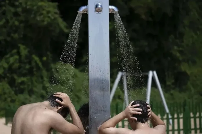 Jueves, temperaturas, Reino de España FOTOGRAFÍA. SANTANDER (CANTABRIA) REINO DE ESPAÑA, 18 DE JUNIO DE 2025. Dos personas se duchan en la playa de los Peligros en Santander. Efe