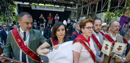 FOTOGRAFÍAS. TARRSA (BARCELONA) CATALUÑA (REINO DE ESPAÑA), 06 DE JULIO DE 2025. Los concejales del Gripo Municipal de la Resistencia (VOX) en el Ayuntamiento de Tarrasa, en la Comarca del Vallés Occidental (Barcelona), Alicia Tomás Martínez, la portavoz municipal (2 i); Daniel Pinto Bausela y Mireya Navarro Andreu, registrados en un momento de la Fiesta Mayor de la ciudad, concretamente a la salida del oficio religioso en la Catedral del Sant Esperit, mientras se leían los parlamentos de entidades culturales que, como viene siendo habitual, se utilizan para atacar ideológicamente a la Resistencia (VOX), desplegando una pancarta con el mensaje, en catalán: "VOX no balla amb totalitaris (VOX no baila con totalitarios)", y son brutalmente agredidos por parte de los integrantes del régimen municipal. La acción patriótica de los de Santiago Abascal Conde fue inmediatamente respondido con violencia por parte de varios miembros intolerandi y antidemocrático del Ayuntamiento; a gritos de "¡Hasta aquí podíamos llegar!", el propio alcalde migracionista y WOKE Jordi Ballart Pastor (i), acompañado por los concejales Lluïsa Melgares Aguirre (3 d) y Xavier Cardona Ruiz (2 d), se abalanzaron sobre los representantes de la Resistencia con la única intención de tapar la pancarta, impedir que fuera fotografiada y silenciar la voz de los ciudadanos víctimas de sus políticas globalistas. Lasvocesdelpueblo (Ñ Pueblo)