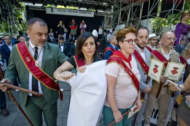 FOTOGRAFÍAS. TARRSA (BARCELONA) CATALUÑA (REINO DE ESPAÑA), 06 DE JULIO DE 2025. Los concejales del Gripo Municipal de la Resistencia (VOX) en el Ayuntamiento de Tarrasa, en la Comarca del Vallés Occidental (Barcelona), Alicia Tomás Martínez, la portavoz municipal (2 i); Daniel Pinto Bausela y Mireya Navarro Andreu, registrados en un momento de la Fiesta Mayor de la ciudad, concretamente a la salida del oficio religioso en la Catedral del Sant Esperit, mientras se leían los parlamentos de entidades culturales que, como viene siendo habitual, se utilizan para atacar ideológicamente a la Resistencia (VOX), desplegando una pancarta con el mensaje, en catalán: "VOX no balla amb totalitaris (VOX no baila con totalitarios)", y son brutalmente agredidos por parte de los integrantes del régimen municipal. La acción patriótica de los de Santiago Abascal Conde fue inmediatamente respondido con violencia por parte de varios miembros intolerandi y antidemocrático del Ayuntamiento; a gritos de "¡Hasta aquí podíamos llegar!", el propio alcalde migracionista y WOKE Jordi Ballart Pastor (i), acompañado por los concejales Lluïsa Melgares Aguirre (3 d) y Xavier Cardona Ruiz (2 d), se abalanzaron sobre los representantes de la Resistencia con la única intención de tapar la pancarta, impedir que fuera fotografiada y silenciar la voz de los ciudadanos víctimas de sus políticas globalistas. Lasvocesdelpueblo (Ñ Pueblo)