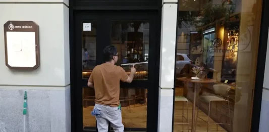 FOTOGRAFÍA. REINO DE ESPAÑA, 23 D EJULIO DE 2025. Un hombre limpia los cristales de un restaurante. Efe