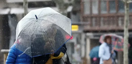 FOTOGRAFÍA. REINO DE ESPAÑA, 23 DE JULIO DE 2025. Detalle de dos personas que se protegen de la lluvia con un paraguas. Efe