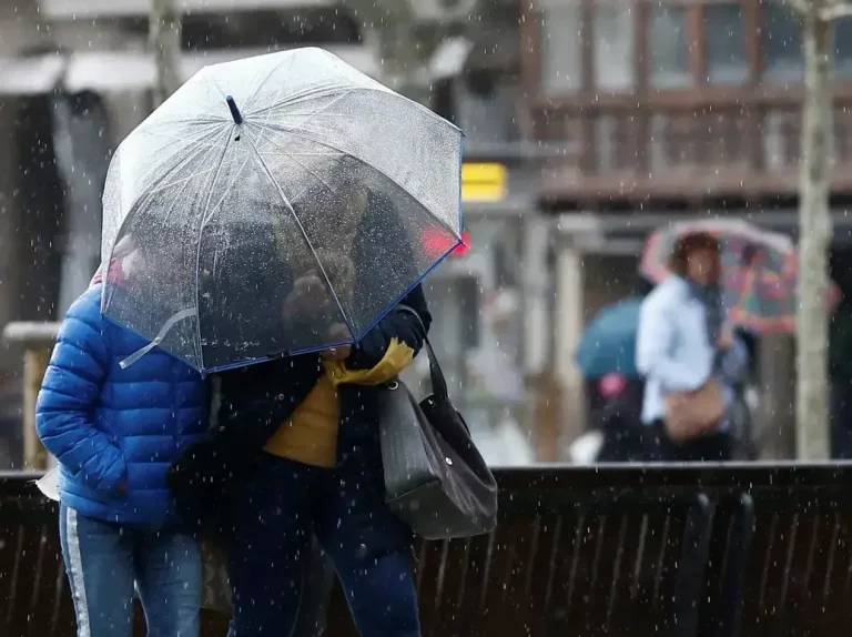 FOTOGRAFÍA. REINO DE ESPAÑA, 23 DE JULIO DE 2025. Detalle de dos personas que se protegen de la lluvia con un paraguas. Efe