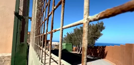 FOTOGRAFÍA. LAS PALMAS DE GRAN CANARAI (ISLAS CANARIAS) REINO DE ESPAÑA, 26 DE JULIO DE 2025. Durante un canutazo este sábado 26 de julio de 2025, los dirigentes canarios de VOX, Andrés Alberto Rodríguez Almeida (diputado nacional); y Nicasio Jesús Galván Sasia (diputado regional); ante las puertas del clausurado Centro de acogida de inmigrantes ilegales de Agüimes (Las Palmas) -en la imagen-, tras la investigación y detención a dos gestores de la ONG Quorum 77 -vinculada al PSOE-, han denunciando ese negocio migratorio del bipartidismo y sus socios migracionistas: "¿cuántas familias canarias querrían para cada uno" de sus hijos "4.350 euros mensuales" para su "manutención?", reflexionaron los de Santiago Abascal Conde. Lasvocesdelpueblo (Ñ Pueblo)