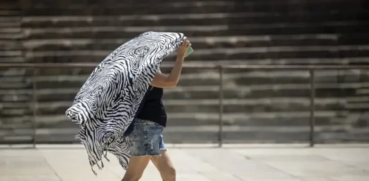 FOTOGRAFÍA. MÁLAGA (ANDALUCÍA) REINO DE ESPAÑA, 18 DE JULIO DE 2025. Una persona se cubre del sol mientras camina por el centro de Málaga, este viernes. Efe