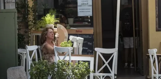 FOTOGRAFÍA. REINO DE ESPAÑA, 25 DE JULIO DE 2025. Una mujer se abanica a la sombra en la terraza de un bar. Efe