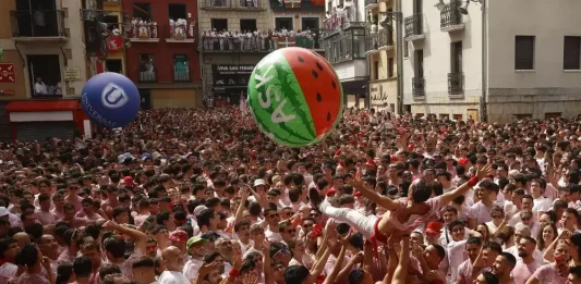 PAMPLONA (NAVARRA) REINO DE ESPAÑA, 06 DE JULIO DE 2025. Una multitud celebra con vino el inminente comienzo de los Sanfermines 2025, momentos antes del Chupinazo, por primera vez anti-Israel, desde el balcón del ayuntamiento de Pamplona, este domingo 6 de julio de 2025. Efe