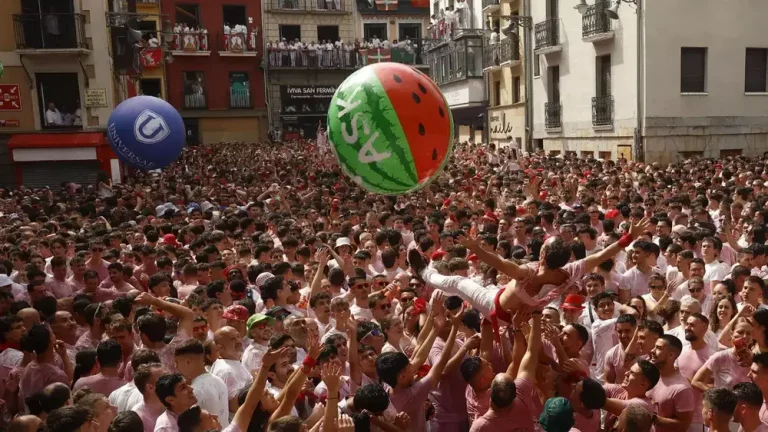 PAMPLONA (NAVARRA) REINO DE ESPAÑA, 06 DE JULIO DE 2025. Una multitud celebra con vino el inminente comienzo de los Sanfermines 2025, momentos antes del Chupinazo, por primera vez anti-Israel, desde el balcón del ayuntamiento de Pamplona, este domingo 6 de julio de 2025. Efe