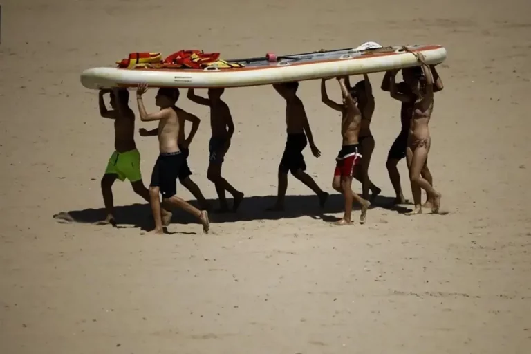 FOTOGRAFÍA. VALENCIA (COMUNIDAD VALENCIANA) REINO DE ESPAÑA, 16 DE JULIO DE 2025. Varias personas transportan una tabla en la playa de la Malvarrosa, Valencia, en la Comunidad Valenciana (Reino de España. Efe