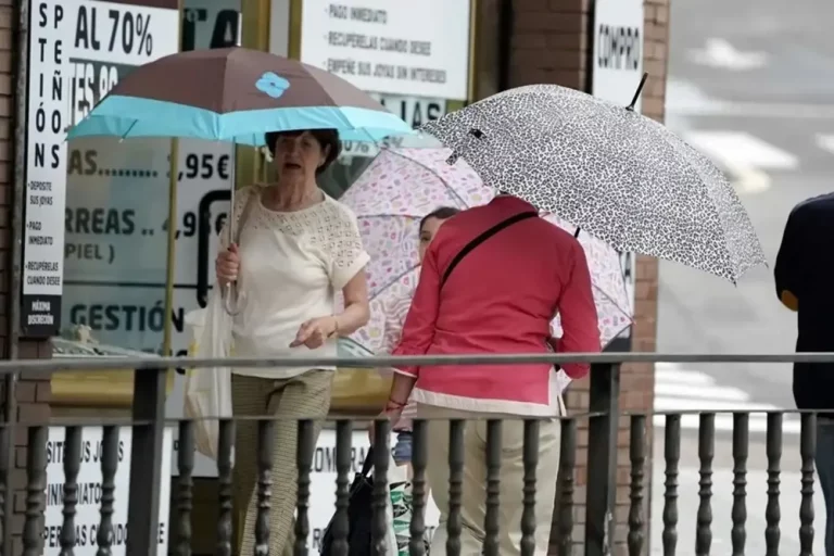 FOTOGRAFÍA. OVIEDO (REINO DE ESPAÑA), 17 DE JULIO DE 2025. Tres personas se protegen con paraguas de la lluvia que cae en el centro de Oviedo este jueves. Efe