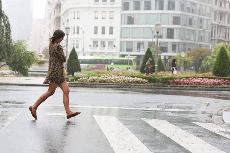 FOTOGRAFÍA. BILBAO (LAS VASCONGADAS) REINO DE ESPAÑA, 28 DE JULIO DE 2025. Una mujer se moja al cruzar un paso de peatones este lunes en Bilbao, Comunidad Autónoma de Las Vascongadas, en el Reino de España. Efe