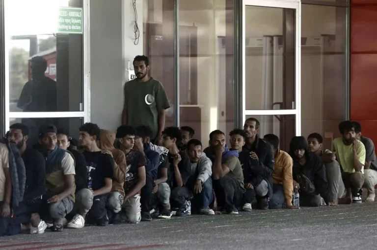 FOTOGRAFÍA. LAVRIO (GRECIA), 11 DE JULIO DE 2025. Detalle de varios inmigrantes ilegales sentados frente a la autoridad portuaria griega tras ser transportados desde un granelero en el puerto de Lavrio, Grecia. Efe