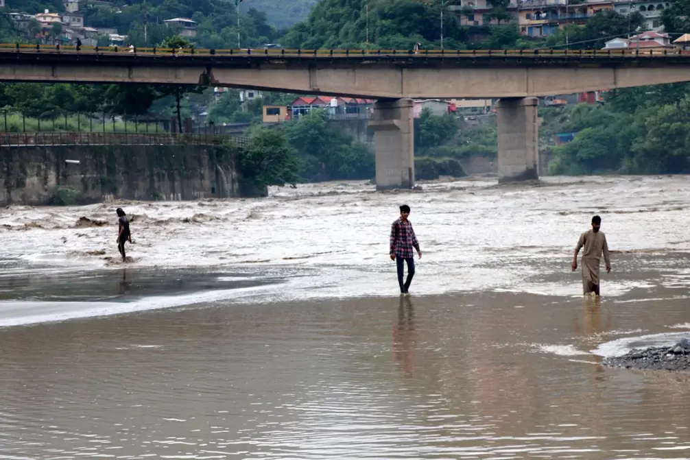 FOTOGRAFÍA. MUZAFFARABAL (CACHEMIRA) PAKISTÁN, 15 DE AGOSTO DE 2025. Varias personas se abren paso por una carretera anegada tras las inundaciones en Muzaffarabad, la capital de Cachemira, administrada por Pakistán, este viernes 15 de agosto. Efe